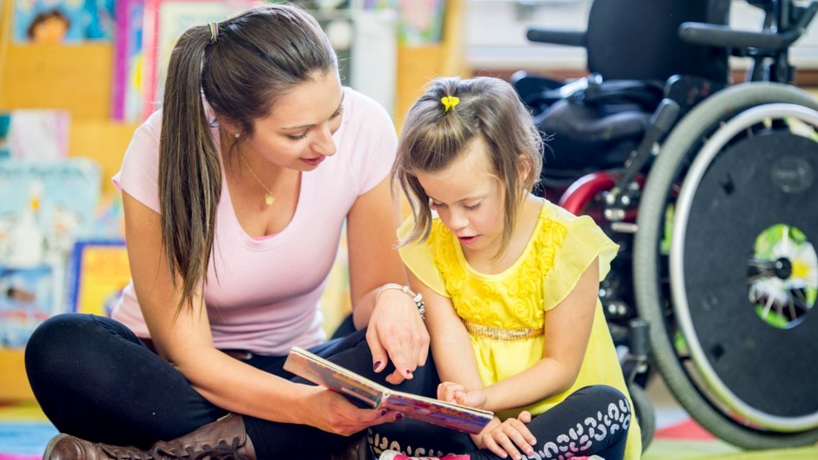 Education Assistant Helping Child Read